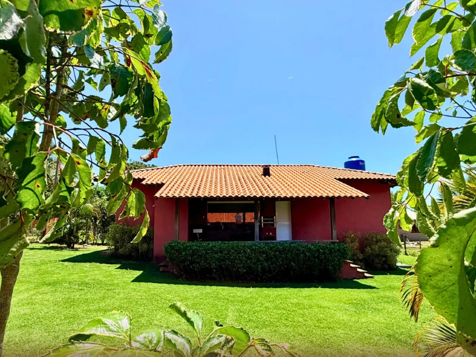 Fachada da Casa Hibisco em meio ao jardim de Saquaíra